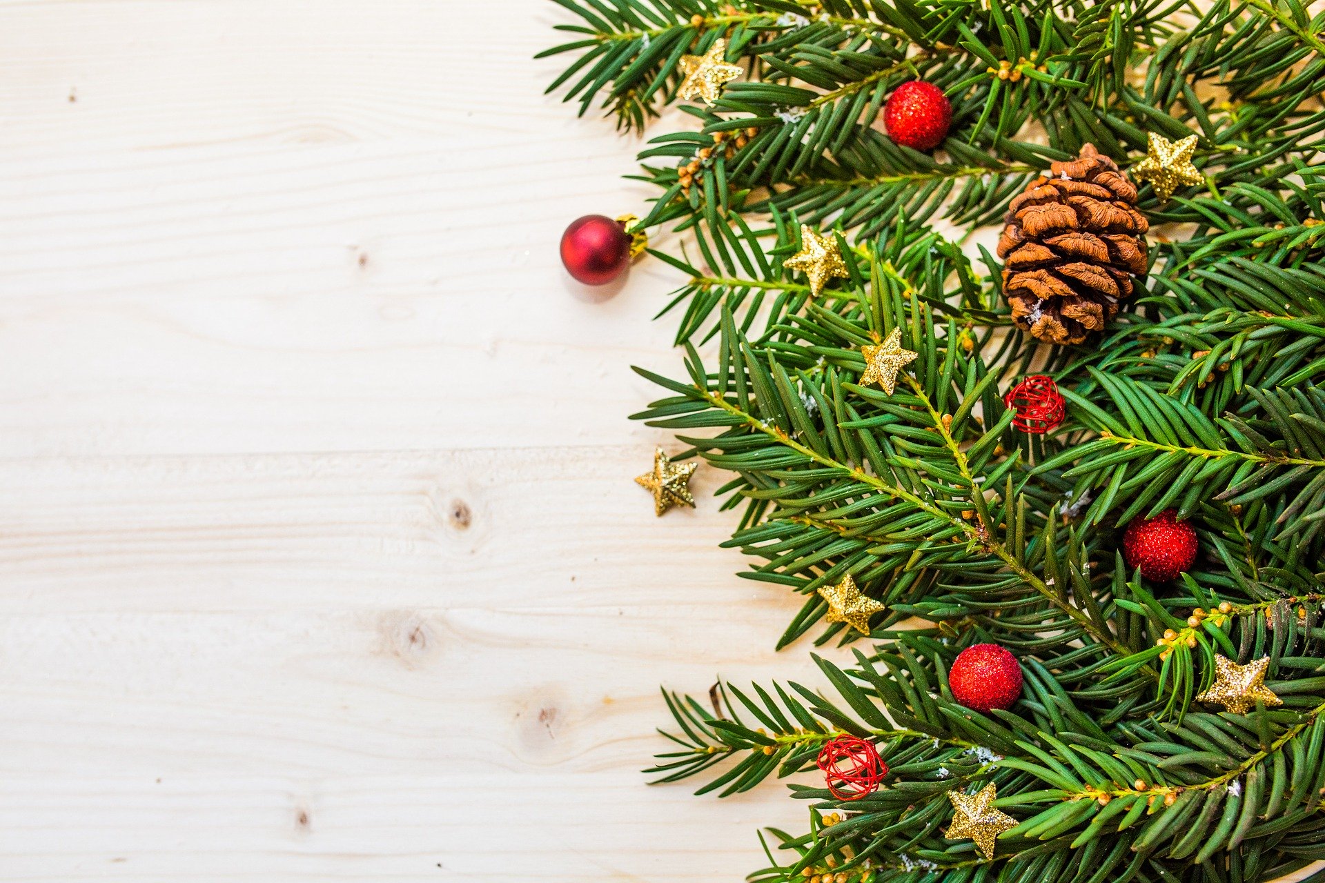 Generic Christmas graphic with pine needles laying on wood.